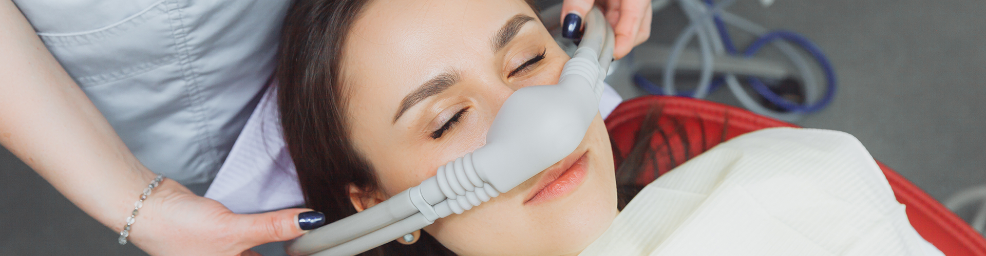 hands putting breathing mask over woman's nose